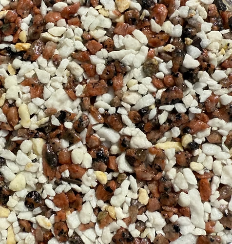 Close-up view of small mixed pebbles in white, red, black, and brown colors.