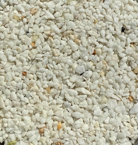 Close-up of small white marble gravel pieces with a few beige and black specks.